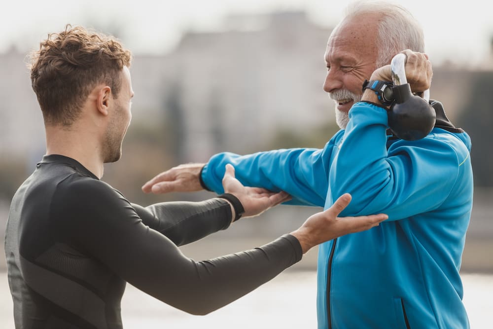 Older male client with personal trainer
