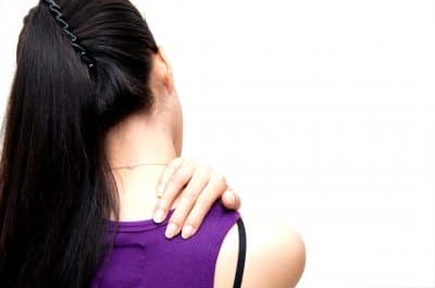 poor posture woman holding shoulder in pain from poor posture